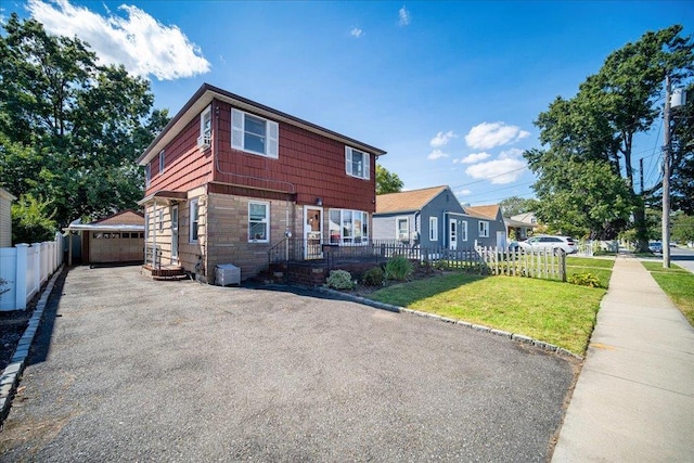 view of front facade with a garage, a front lawn, and an outdoor structure