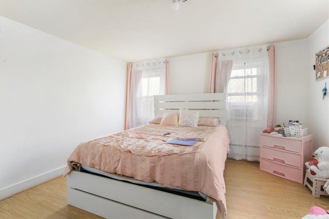 bedroom featuring light hardwood / wood-style floors and multiple windows