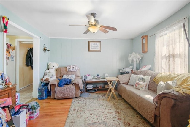 interior space with hardwood / wood-style flooring, ceiling fan, and wood walls