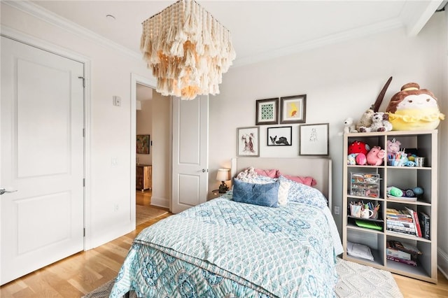 bedroom with a chandelier, wood-type flooring, and ornamental molding