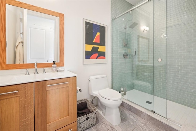 bathroom featuring vanity, toilet, and a shower with shower door