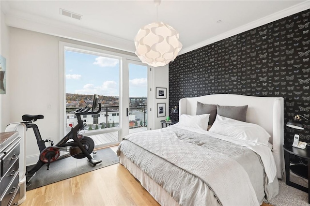 bedroom with hardwood / wood-style floors, access to outside, and crown molding