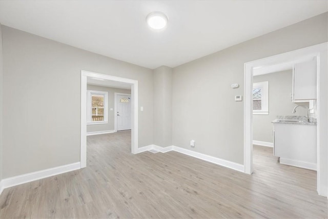 unfurnished room with light wood-type flooring and sink