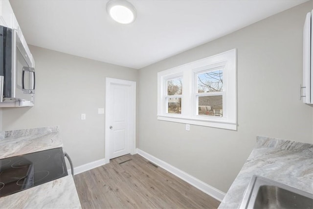 clothes washing area with sink and light hardwood / wood-style floors