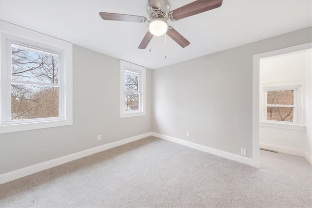 carpeted spare room with ceiling fan