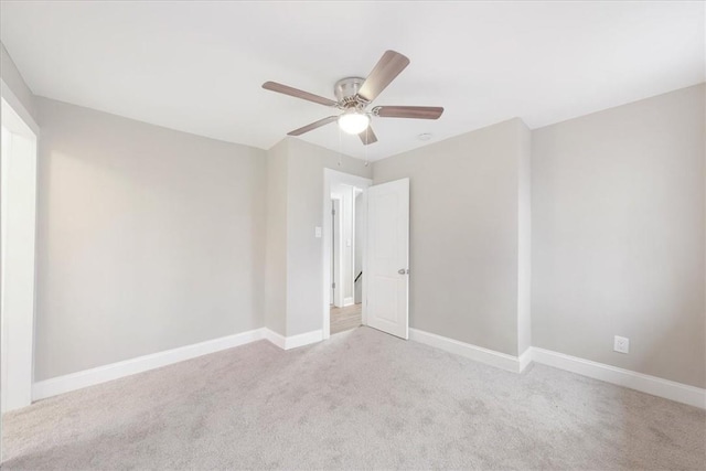 carpeted spare room featuring ceiling fan