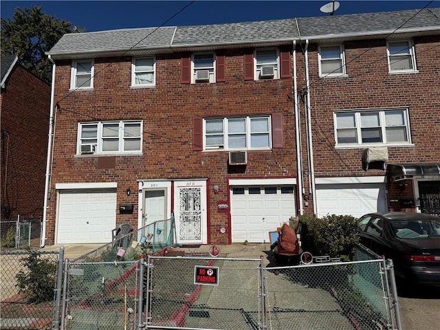 view of property featuring a garage and cooling unit