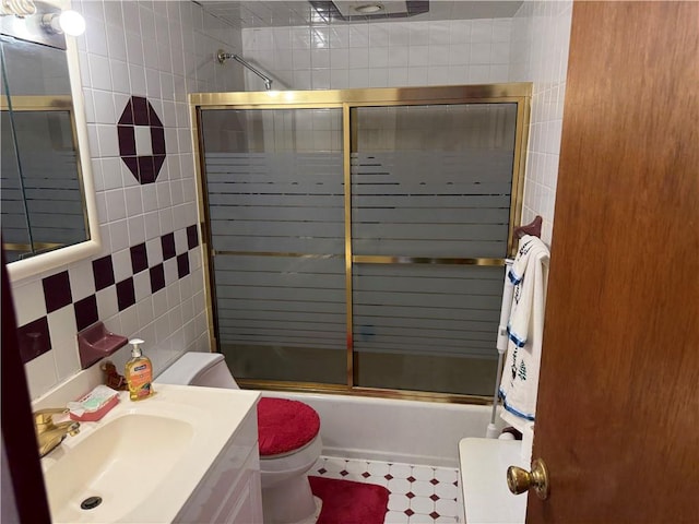 full bathroom with vanity, toilet, tile walls, and enclosed tub / shower combo