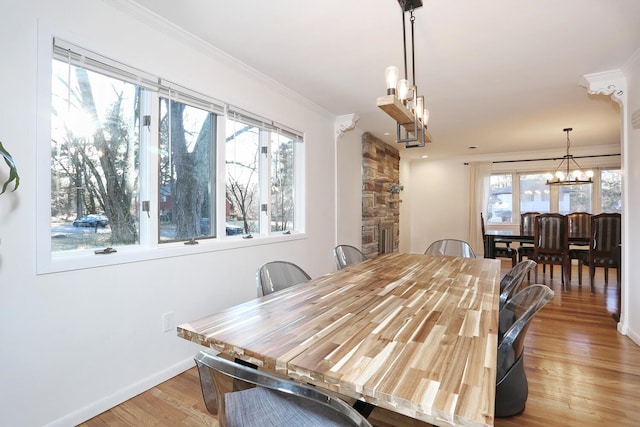 dining room with hardwood / wood-style floors, an inviting chandelier, and crown molding