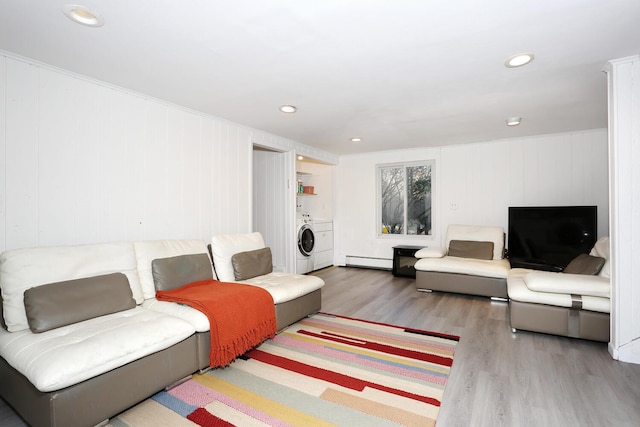 living room with washer / clothes dryer, hardwood / wood-style floors, and a baseboard heating unit