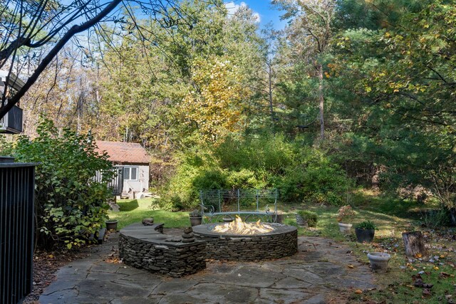 view of patio featuring a fire pit and an outbuilding