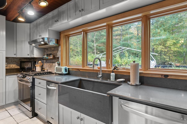 kitchen featuring white cabinets, sink, appliances with stainless steel finishes, tasteful backsplash, and light tile patterned flooring