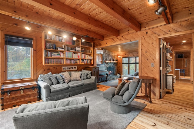 living room with wood walls, a wood stove, light hardwood / wood-style flooring, beam ceiling, and wood ceiling