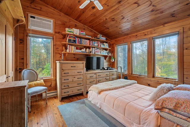 bedroom with ceiling fan, light hardwood / wood-style flooring, a wall mounted AC, wood walls, and wood ceiling