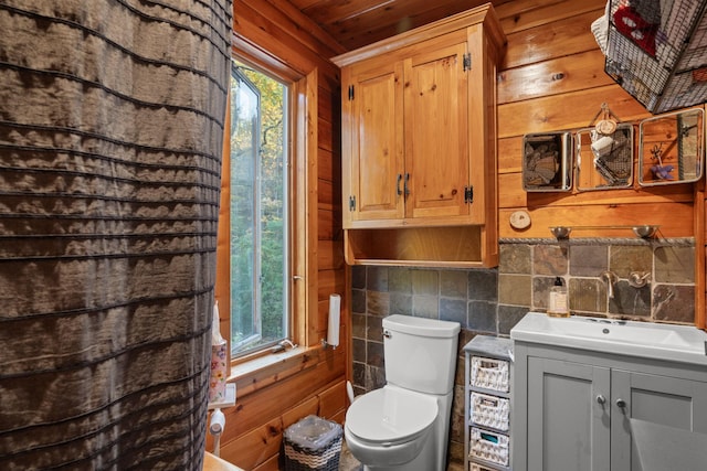 bathroom featuring vanity, backsplash, wooden walls, toilet, and wood ceiling