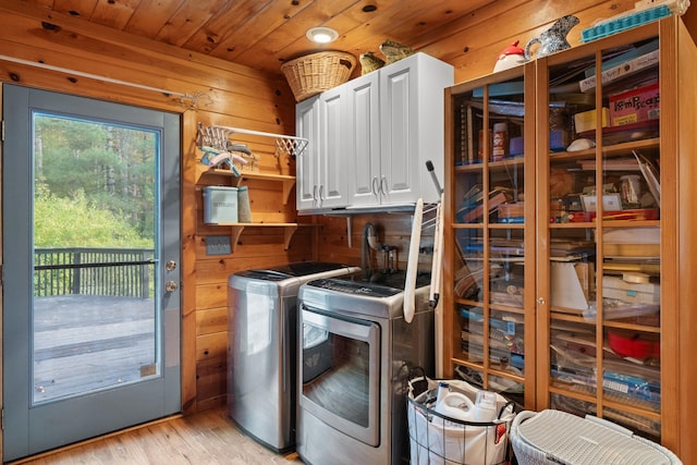 laundry room featuring cabinets, wooden walls, light hardwood / wood-style flooring, separate washer and dryer, and wood ceiling