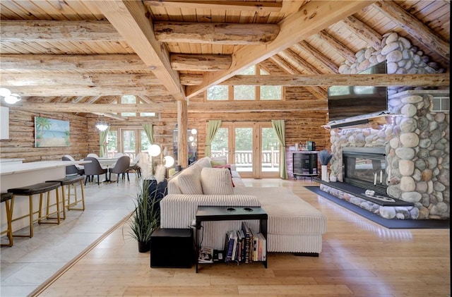 living room featuring a stone fireplace, wood-type flooring, wooden ceiling, and a wealth of natural light