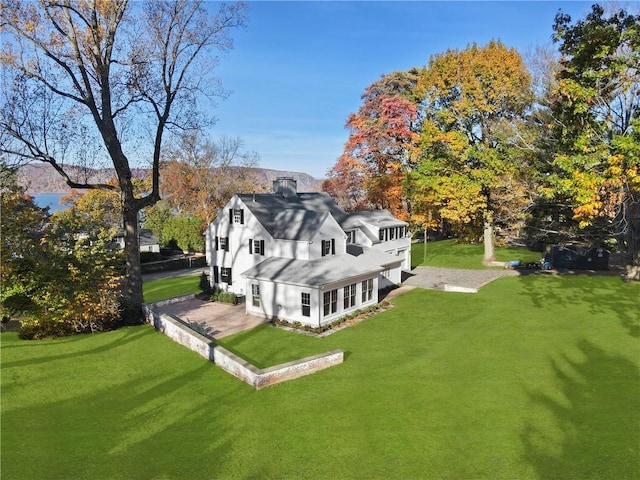 205 River Rd, Briarcliff Manor, NY 10510 - rear view of house with a yard, a chimney, a shingled roof, and a patio