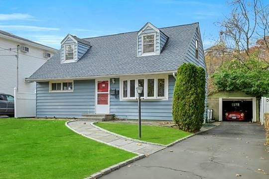 cape cod house with a garage and a front lawn