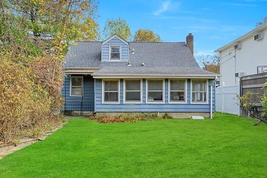 rear view of property featuring a lawn