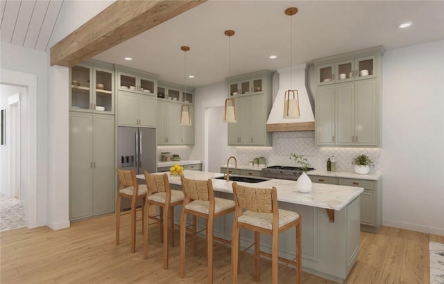 kitchen with stainless steel fridge, backsplash, a sink, premium range hood, and beam ceiling