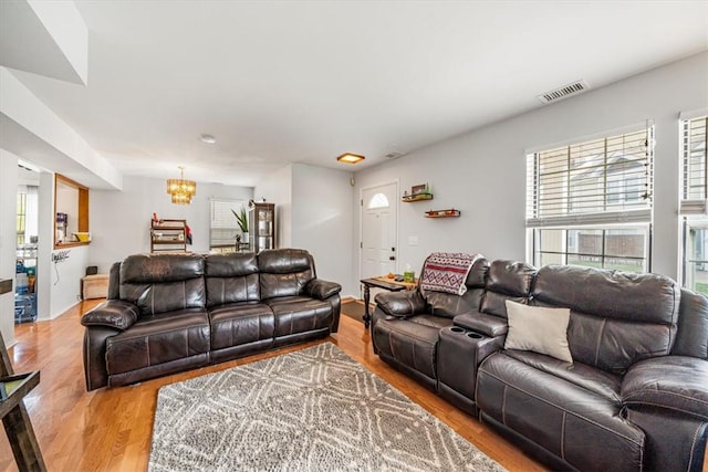 living room featuring a chandelier and light hardwood / wood-style flooring