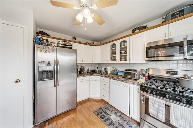 kitchen featuring tasteful backsplash, white cabinetry, light hardwood / wood-style floors, and appliances with stainless steel finishes