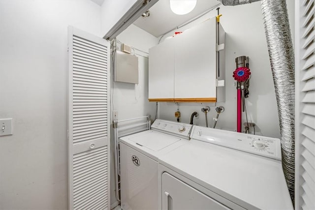 laundry room featuring cabinets and washer and clothes dryer