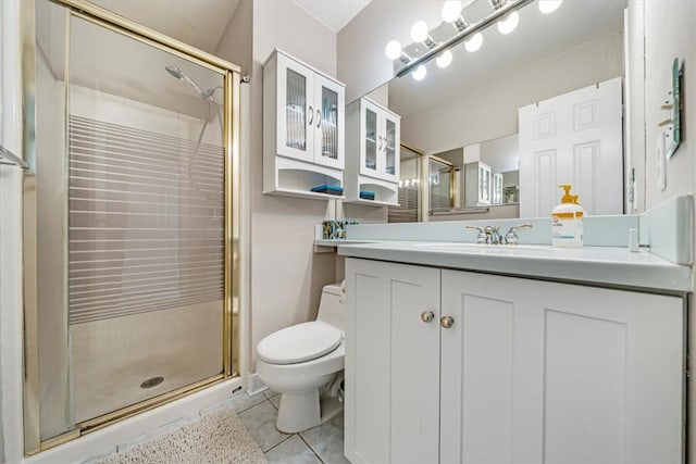 bathroom with tile patterned floors, vanity, toilet, and a shower with door