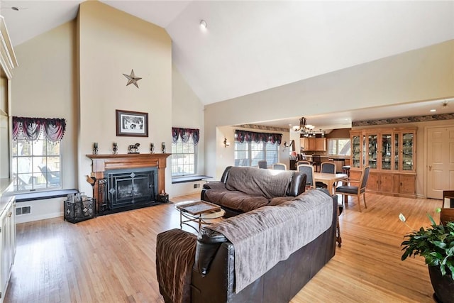 339 Jessup Rd, Florida, NY 10921 - living room with high vaulted ceiling, a chandelier, a fireplace with flush hearth, and light wood-style flooring