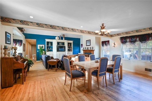 dining space featuring a notable chandelier and light wood-type flooring