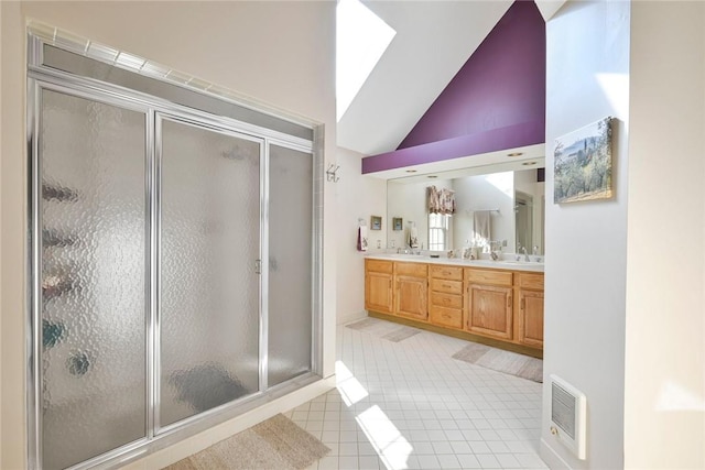 bathroom with tile patterned floors, vanity, a shower with shower door, and high vaulted ceiling