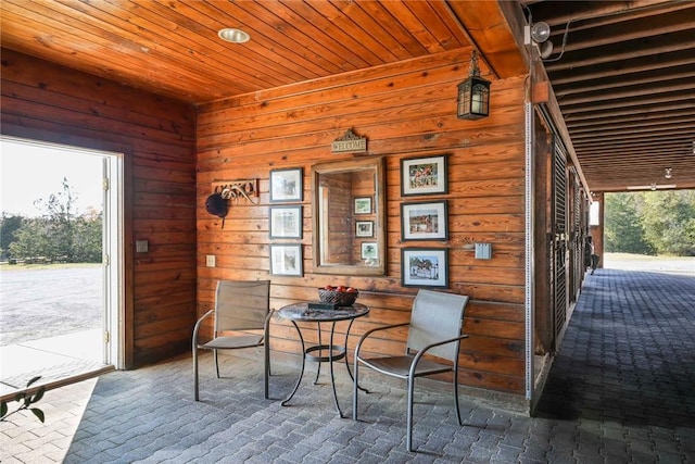 dining space featuring wood walls and wood ceiling