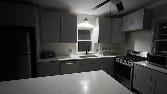 kitchen featuring sink, gray cabinetry, light stone counters, and black appliances