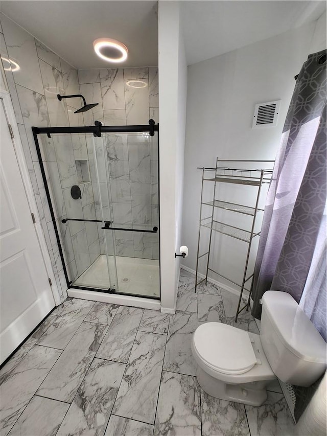 bathroom featuring tiled shower and toilet