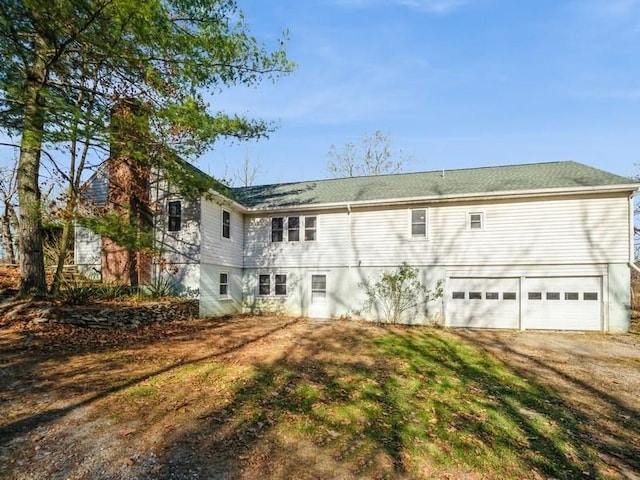 rear view of house featuring a garage