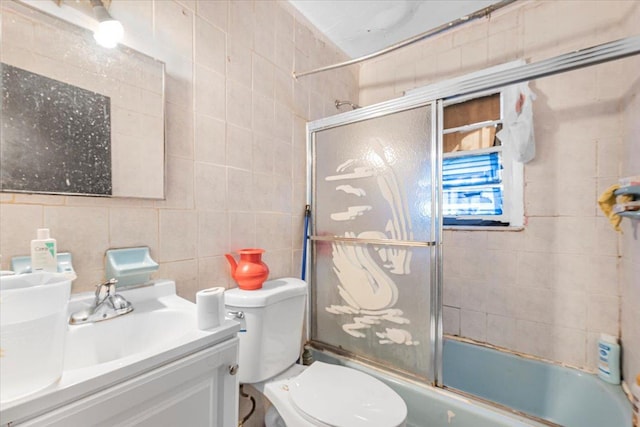 full bathroom with vanity, backsplash, bath / shower combo with glass door, toilet, and tile walls