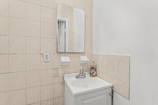 bathroom featuring vanity and tile walls