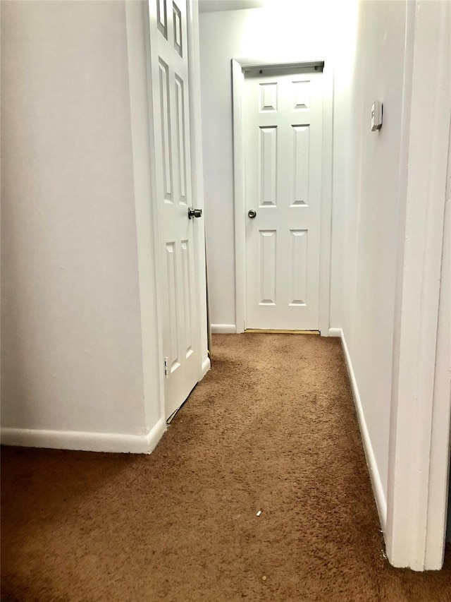 hallway featuring dark carpet