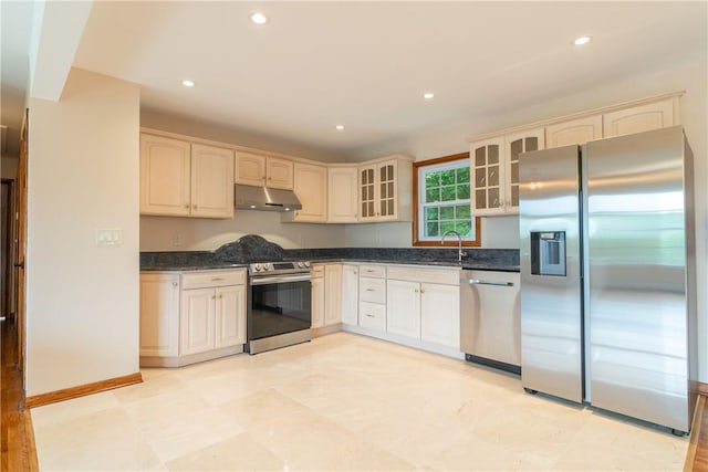 kitchen featuring recessed lighting, appliances with stainless steel finishes, glass insert cabinets, a sink, and under cabinet range hood