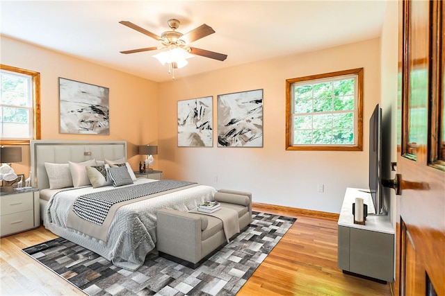 bedroom featuring light wood-style floors, baseboards, and a ceiling fan