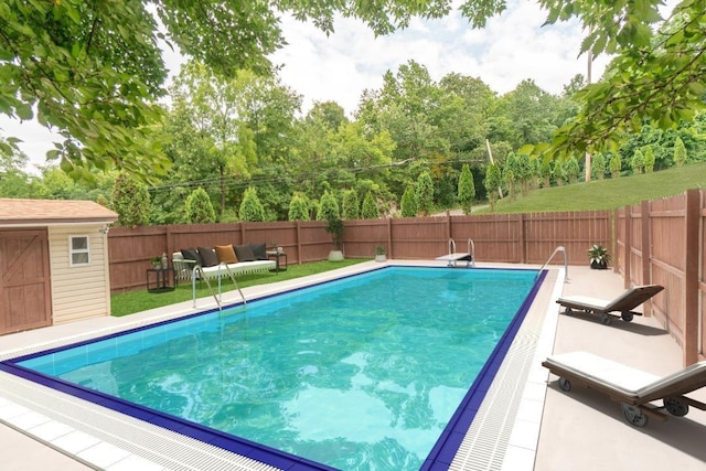 view of swimming pool featuring a fenced backyard, a shed, a fenced in pool, and an outbuilding