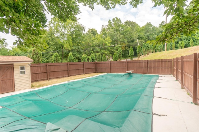 view of pool featuring a fenced backyard, a fenced in pool, and an outbuilding