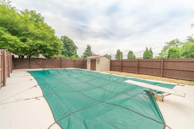 view of swimming pool with a storage shed, a patio area, an outbuilding, and a fenced backyard