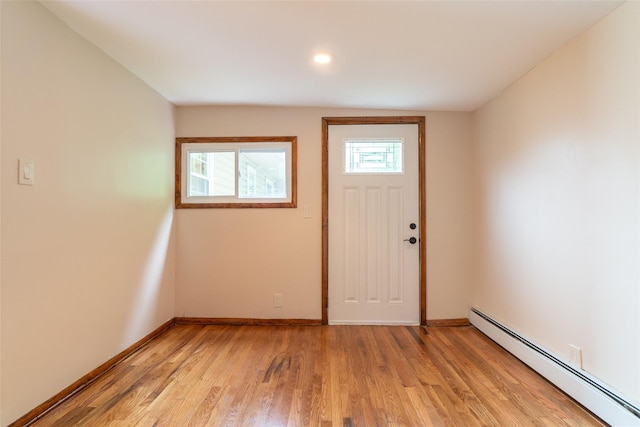 entrance foyer with light wood finished floors, baseboards, and baseboard heating