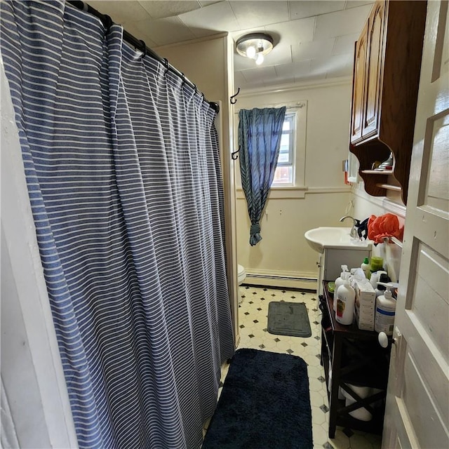 bathroom with a shower with curtain, crown molding, vanity, and a baseboard heating unit