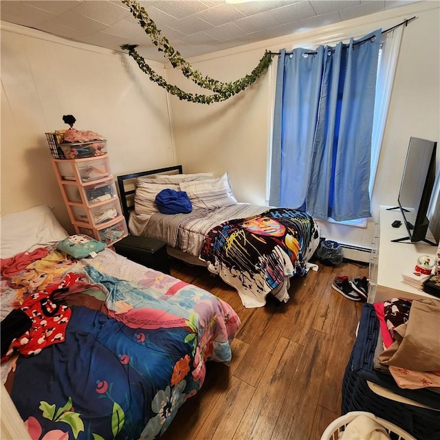 bedroom featuring wood-type flooring and baseboard heating