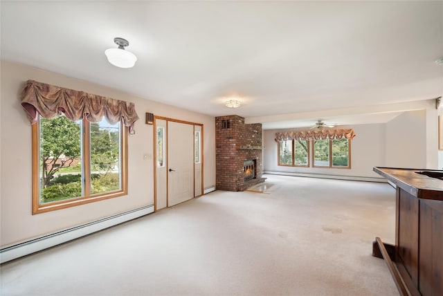 unfurnished living room featuring plenty of natural light, a fireplace, light carpet, and a baseboard heating unit