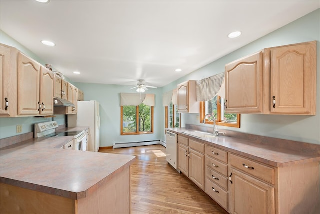 kitchen with a wealth of natural light, sink, a baseboard radiator, and white appliances