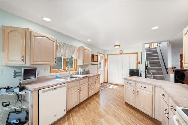 kitchen featuring light wood-type flooring, light brown cabinets, white appliances, and sink